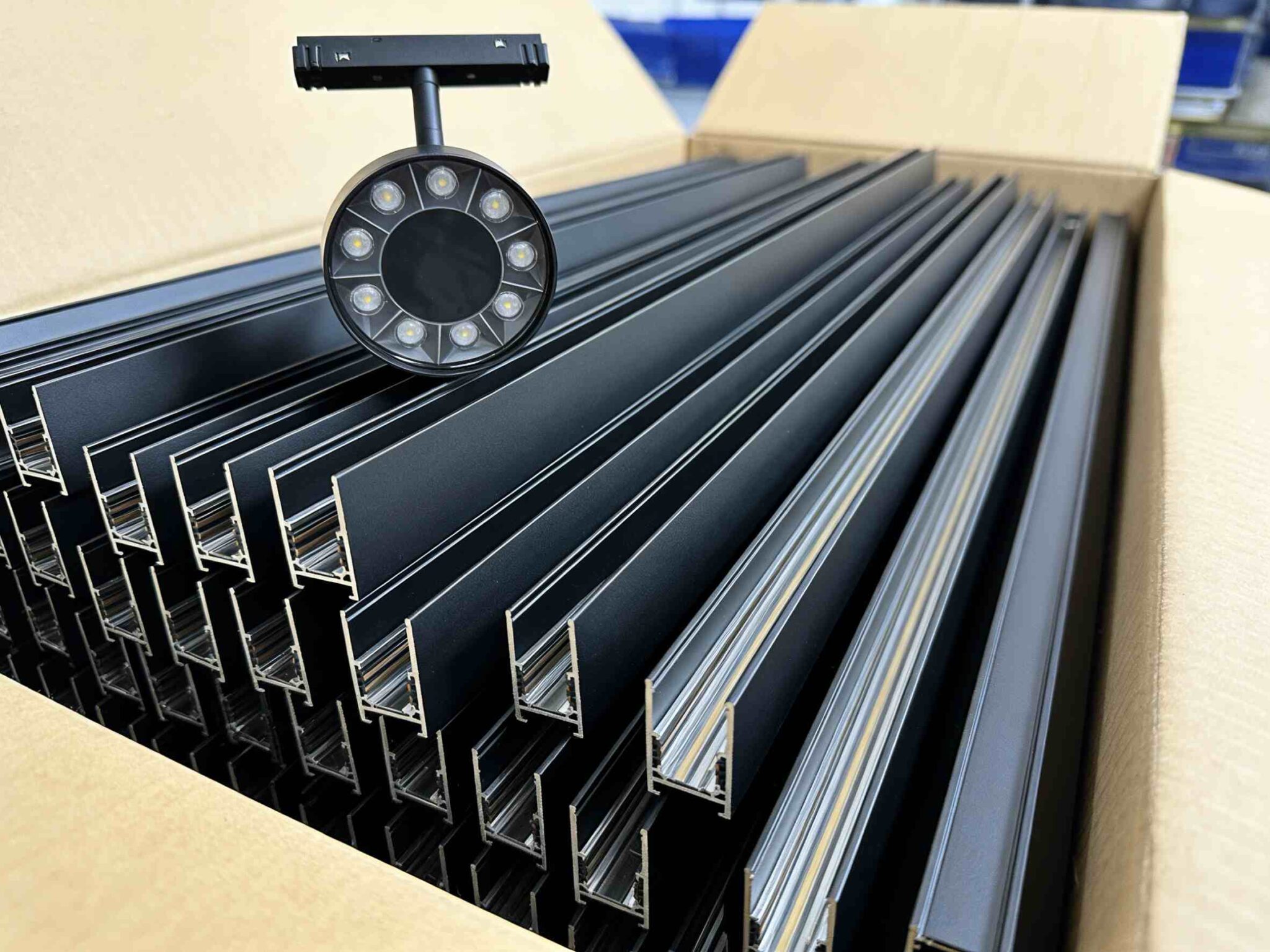 Black magnetic track profiles packed in a carton with a ring spotlight on top